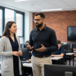 Omer and Jessica discussing IT support inside a UK school ICT classroom.