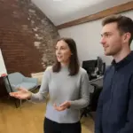Jessica and Adam discussing notification settings inside a UK care facility office.