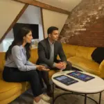 Sara and Zak discussing email migration planning inside a UK office environment.