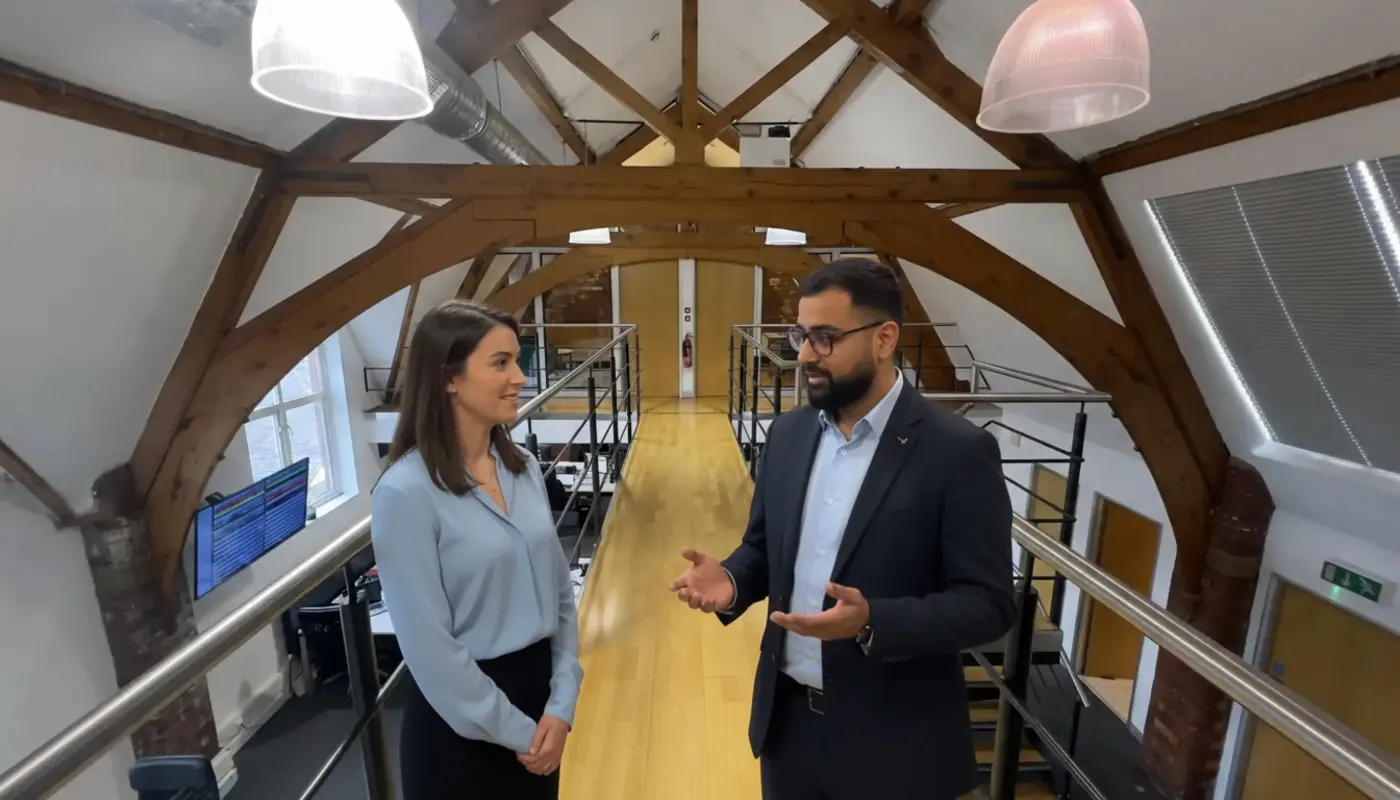 Omer and Jessica discussing AI insights inside a UK office during a real collaborative moment.