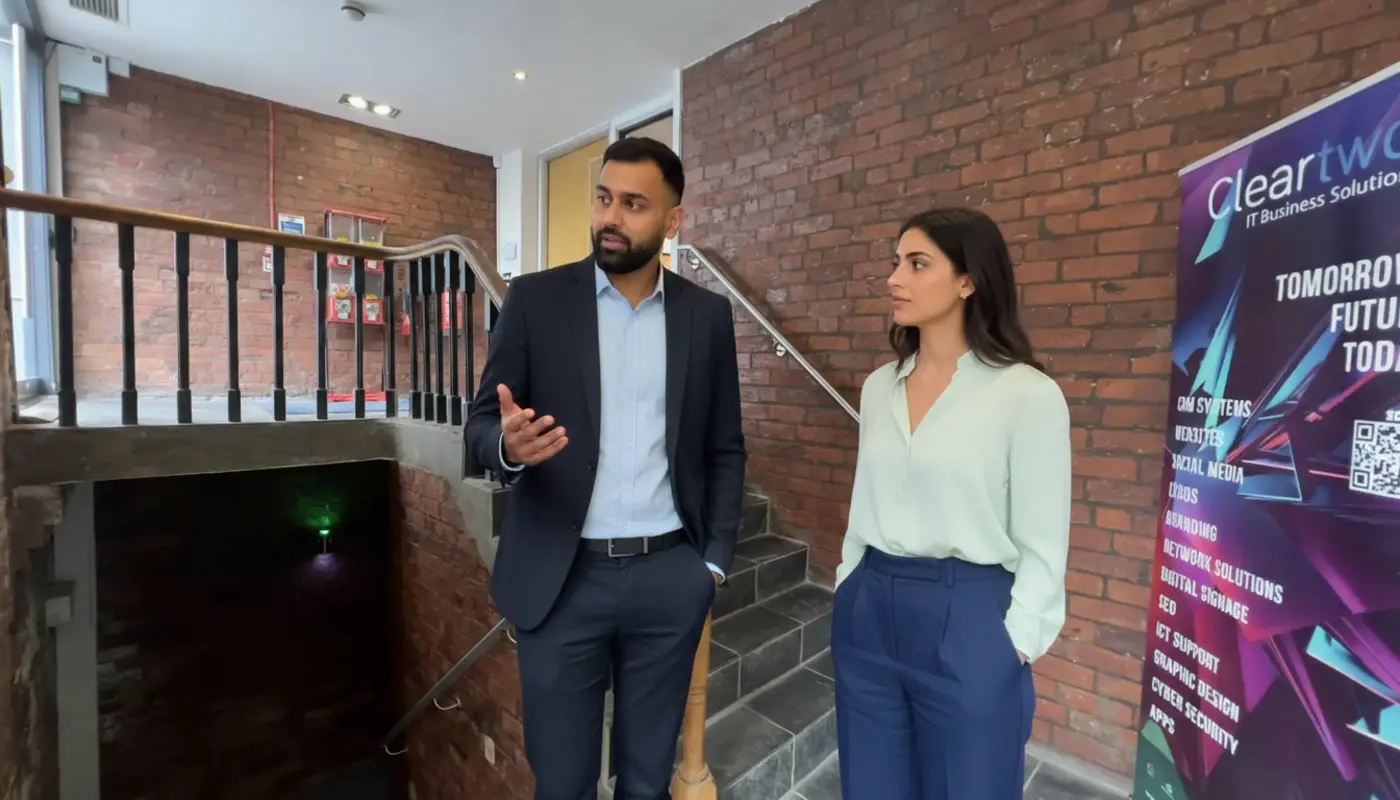 Omar and Sara discussing AI strategy inside a UK office during a real collaborative work moment.