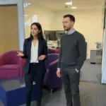 Sara and Adam discussing voice AI inside a UK office, mid-collaboration.