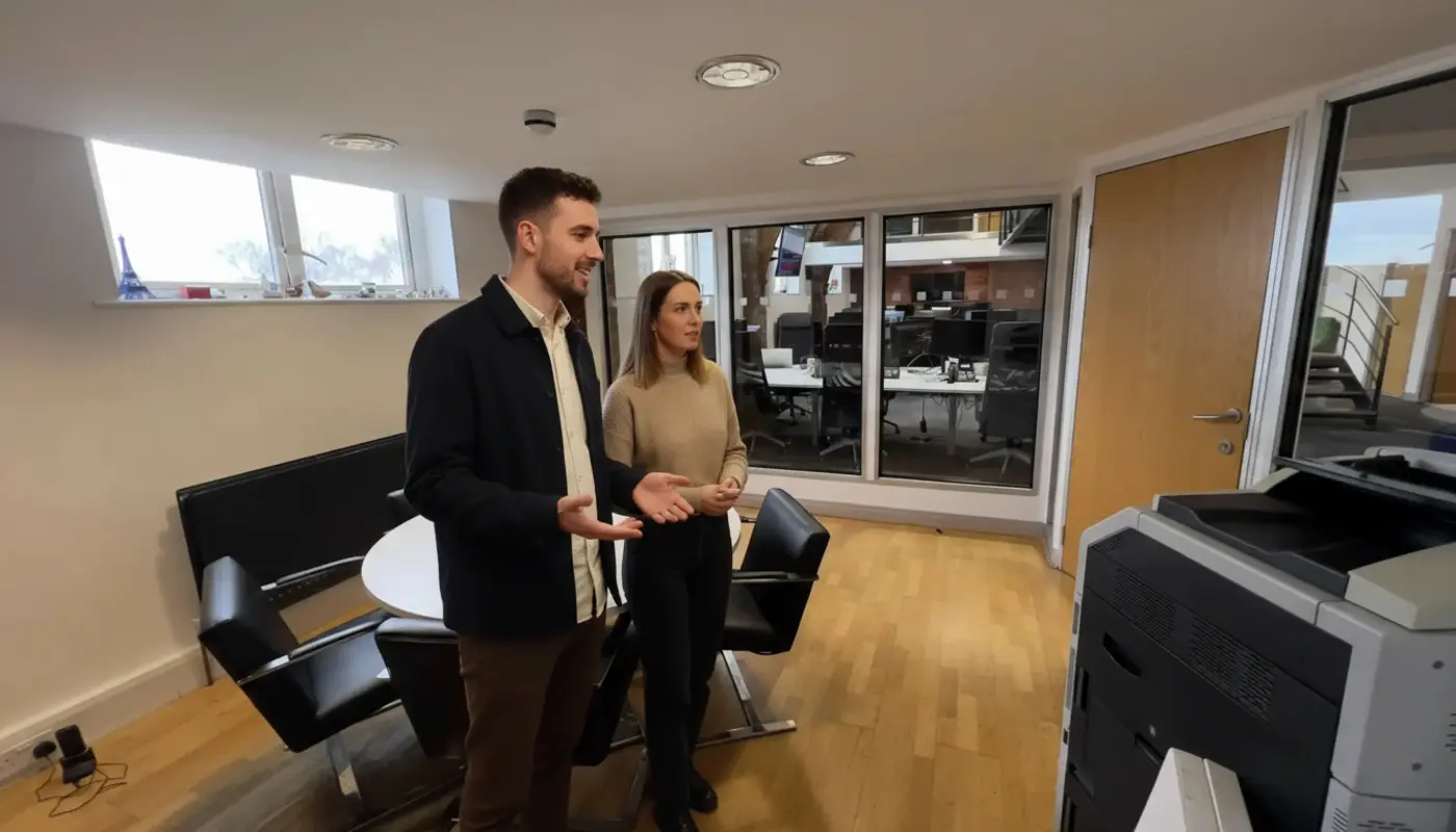 Adam and Jessica discussing TikTok trend planning inside a UK creator studio.