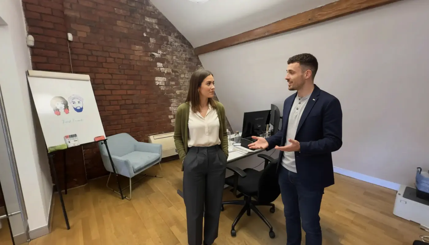 Adam and Jessica collaborating in a UK office discussing SEO and social media strategy.