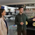 Jessica and Adam collaborating in a UK creative studio, discussing logo design concepts.