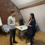 Zak and Sara discussing TikTok strategy inside a UK creator studio, captured mid-collaboration.