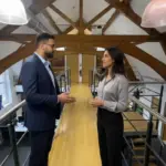 Omer and Sara discussing AI strategy inside a modern UK office, captured mid‑discussion.