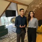 Zak and Sara discussing AI concepts inside a UK office, mid‑conversation.